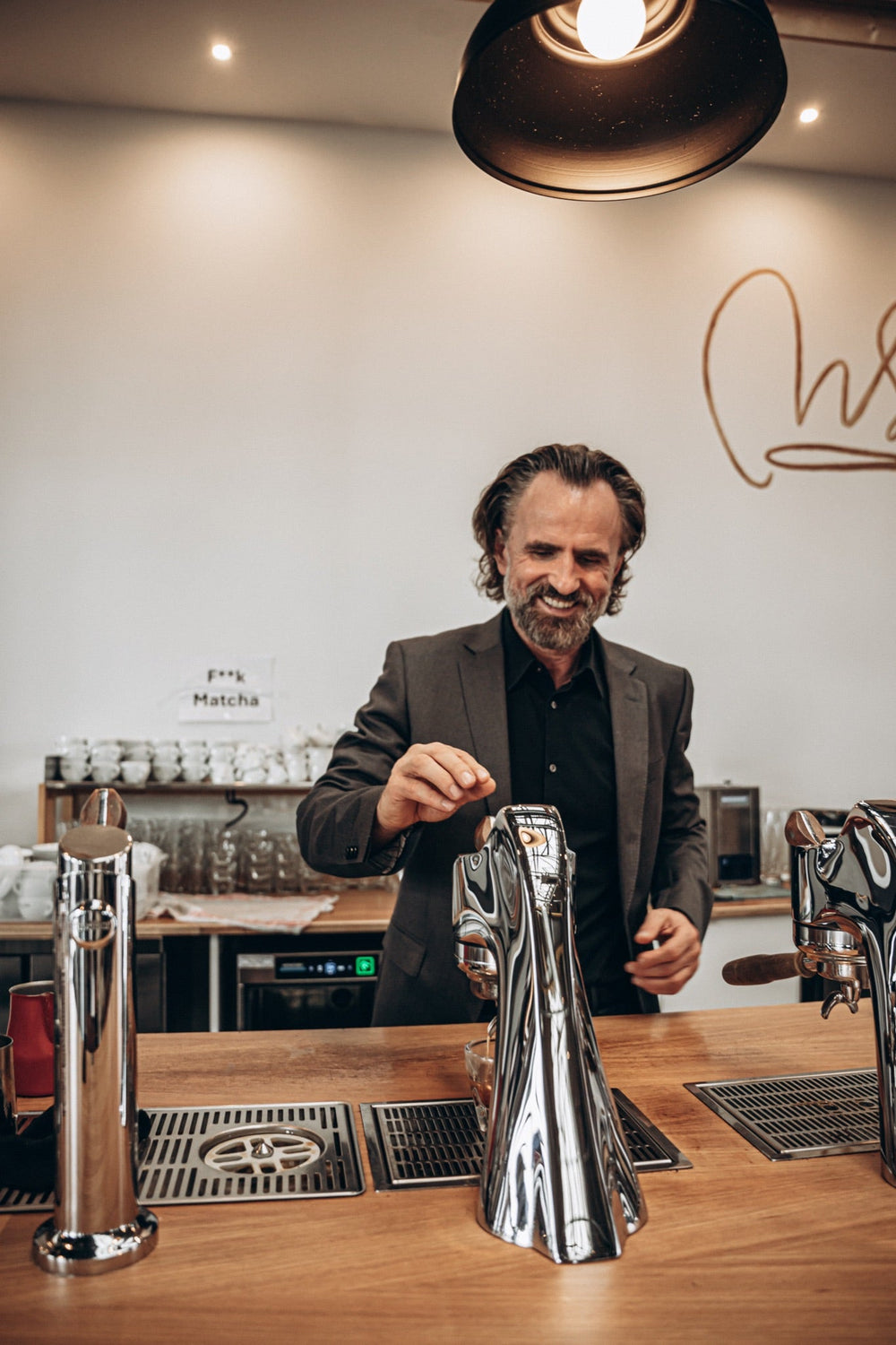 Dritan Alsela vor dem Roastery-Schriftzug