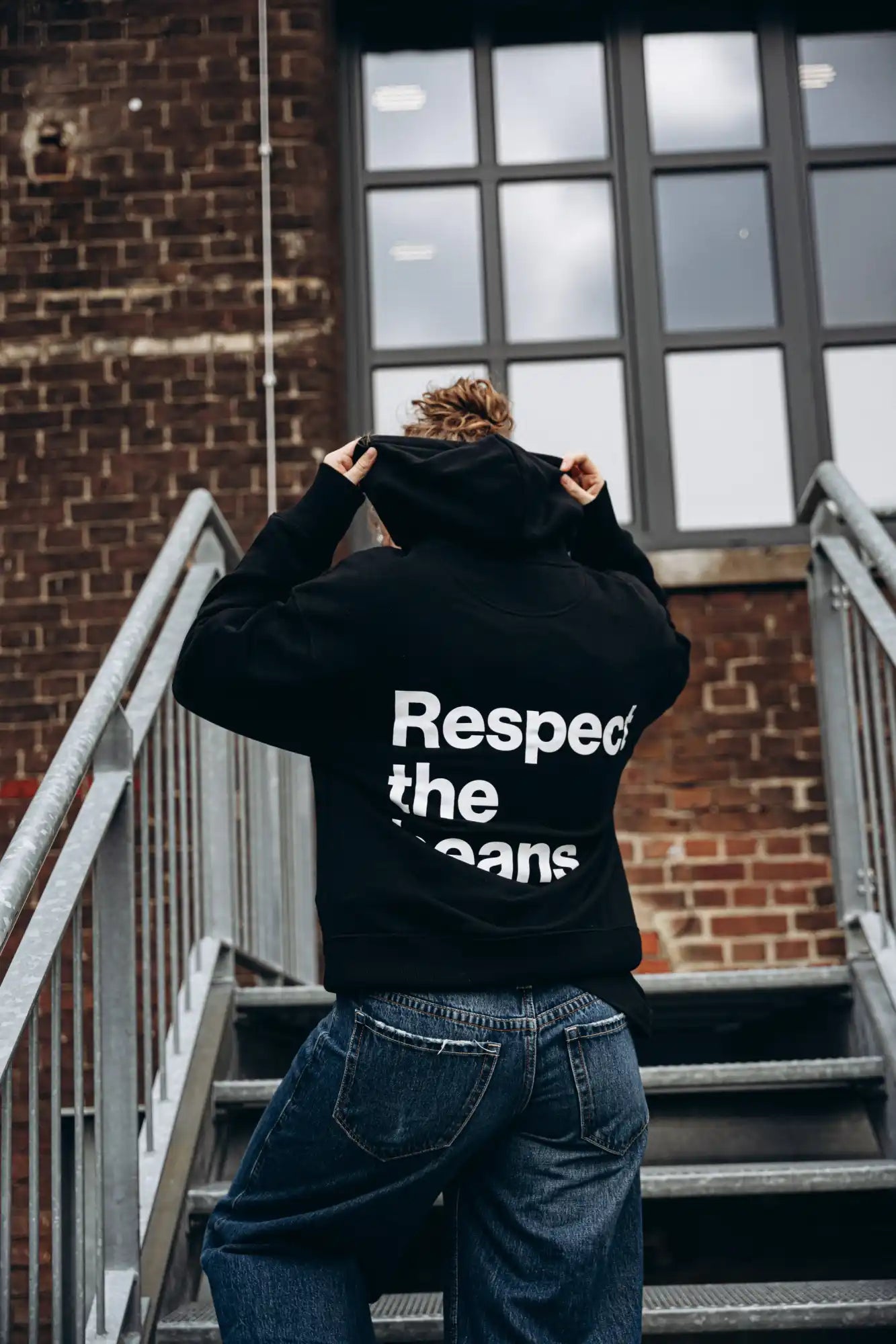 Black hoodie with ’respect the jeans’ text in white.