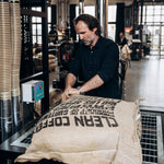 Dritan Alsela öffnet einen Sack Rohkaffee in der Rösterei