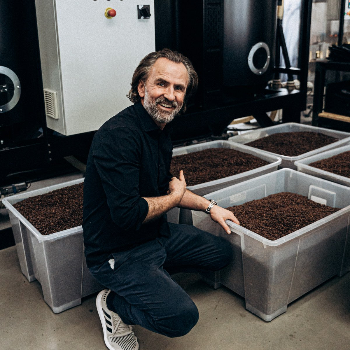 Dritan Alsela neben Kisten mit frisch geröstetem Kaffee