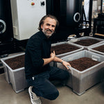 Dritan Alsela neben Kisten mit frisch geröstetem Kaffee