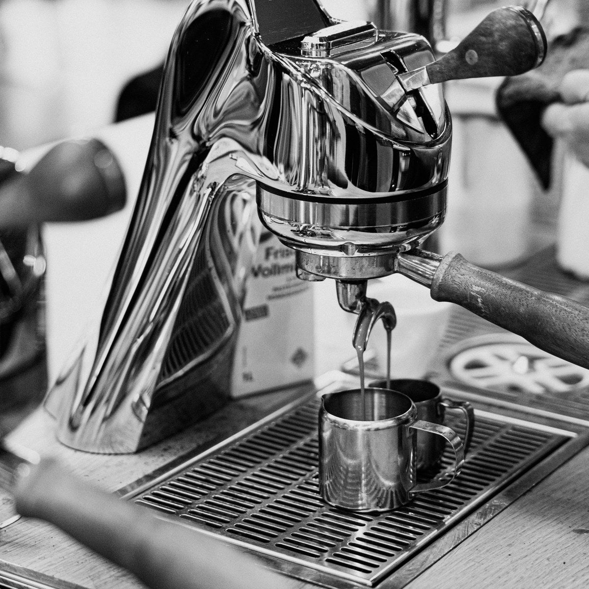 Espresso läuft aus einer Hebel-Espressomaschine in ein Kännchen