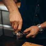 Barista tampt Kaffee im Siebträger