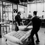 Dritan Alsela trägt Säcke mit Rohkaffee durch die Rösterei