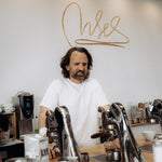 Dritan Alsela an der Espressobar mit Alsela-Schriftzug an der Wand
