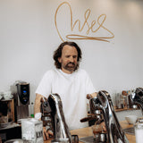 Dritan Alsela an der Espressobar mit Alsela-Schriftzug an der Wand