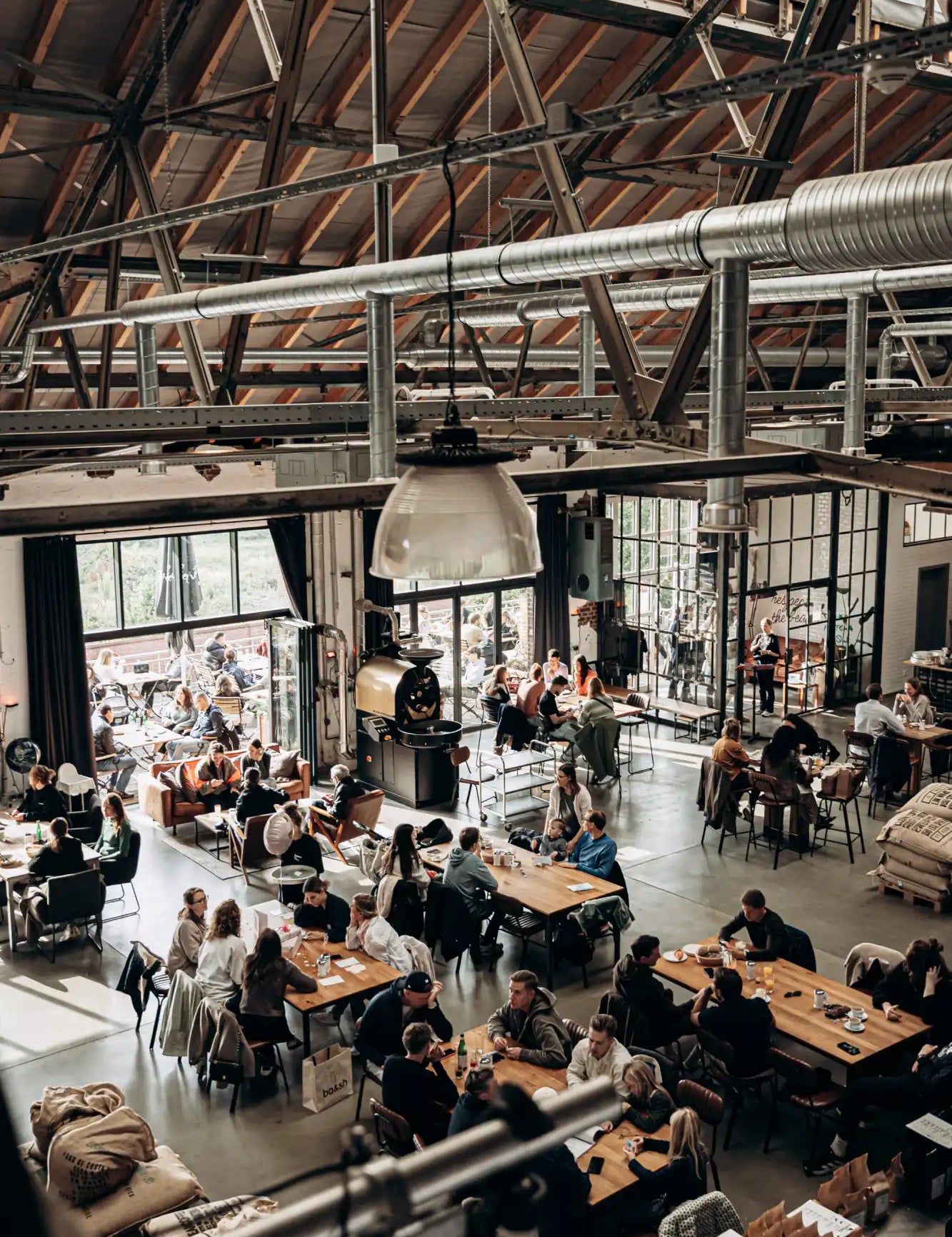 Industrial-style pendant light with exposed metal frame and glass globe, white color.