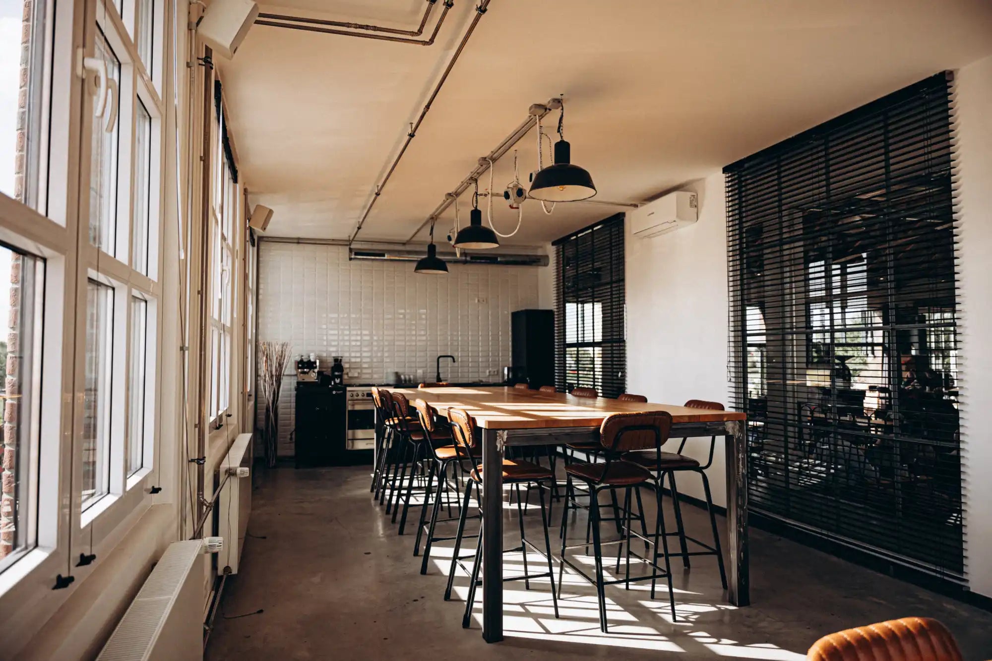 Wooden dining table with metal legs and black chairs.